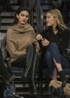 two women sitting next to each other at a basketball game