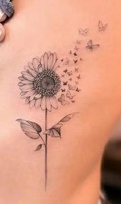 a woman with a tattoo on her stomach has a sunflower and butterflies flying around