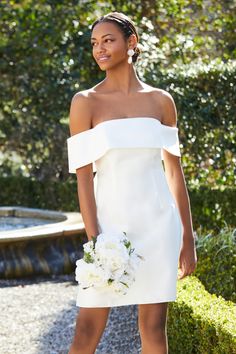 a woman in a white dress holding a bouquet