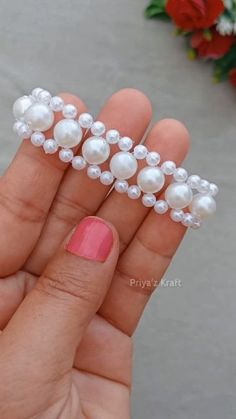 a woman's hand holding some fake pearls