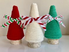 three crocheted christmas trees sitting next to each other