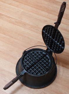 a waffle iron sitting on top of a wooden table