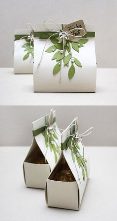 two white boxes with green leaves on them, one is open and the other is closed