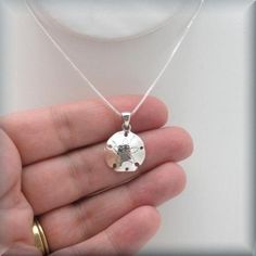 "This necklace features a beautifully detailed sand dollar pendant. Highly polished and absolutely lovely - the perfect necklace for summer! Pendant is a bit more than 1/2\" long (16 mm). All components, including box chain, are sterling silver. Coordinating earrings can be found here: https://www.etsy.com/listing/277982012/sand-dollar-earrings-sterling-silver?ref=shop_home_active_68 Jewelry is packaged in a cotton lined box for gift-giving. See more Bonny Jewelry at http://bonnyjewelry.etsy.com Sterling Silver Pendant Jewelry For Beach, Sterling Silver Pendant Necklace For Beach, Minimalist Sterling Silver Jewelry For Beach, Sterling Silver Starfish Charm Pendant Necklace, Sterling Silver Pendant Necklace With Starfish Charm, Silver Round Beach Necklace, Silver Necklace For Beach, Sand Dollar Earrings, Sand Dollar Necklace