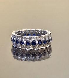 DeKara Designs Collection Metal- 14K White Gold, .583. Stones- Genuine Round Blue Sapphires 20-24 Round 1.60-1.90 Carats, 154-178 Round Diamonds F-G Color VS1-VS2 Clarity 0.60-0.85 Carats (Carat weight and Number of Stones Depends on your finger size) Size- 3-13 Band is 6.5 MM Wide and has a Height of 2 MM. Please indicate your specific size by sending me a conversation on etsy, or putting it in the notes of the transaction. Band will be made in your size within 5-7 working days. Will start work Blue Sapphire Wedding Ring With Diamond Accents, Blue Bridal Jewelry With Diamond Accents In Cubic Zirconia, Blue Round Wedding Ring, Sapphire Round Eternity Band For Wedding, Blue Sapphire Anniversary Ring With Diamond Accents, Elegant Sapphire Eternity Band For Anniversary, Blue Brilliant Cut Jewelry For Wedding, Luxury Halo Eternity Band For Wedding, Blue Round Jewelry With Pave Setting