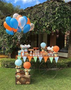 an outdoor party with balloons and desserts