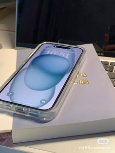 an iphone is sitting on top of a laptop