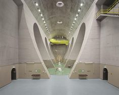 the inside of an empty building with concrete walls and arches on either side of it