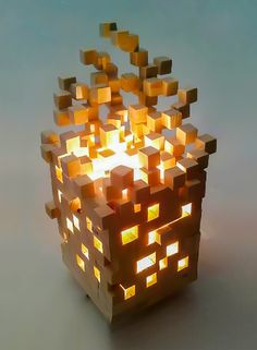 a lit candle that is made out of cubes