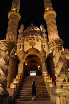 a woman standing in front of an ornate building