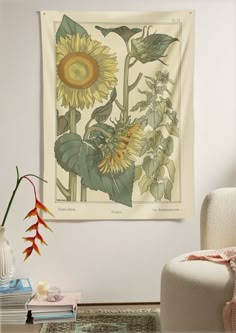 a large sunflower is hanging on the wall next to a white chair and vase