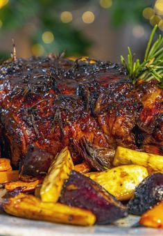 a large piece of meat and some vegetables on a white plate with lights in the background