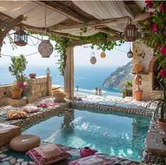 an outdoor swimming pool with lots of plants and flowers on the ground next to it