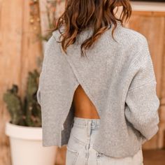 the back of a woman's sweater that has been cut out and is standing in front of a potted plant