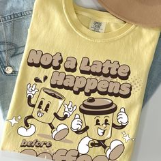 Step up your coffee game with this eye-catching and playful "Not A Latte Happens Before Coffee" T-shirt. Emblazoned with retro cartoon characters in a fun y2k style, this Comfort Colors® shirt is an ideal choice for any coffee aficionado. Its vibrant design and comfortable fit make it an essential addition to your wardrobe, because, let's face it, for many of us, coffee is a must before anything else! DTF printed design is durable for 50+ washes. SIZING: COMFORT COLORS® (1717): unisex t-shirt wi Coffee Crew Neck Top With Slogan, Coffee Colored Crew Neck Top With Slogan, Casual Coffee-colored Slogan Top, Coffee Colored Graphic Tee With Screen Print, Coffee Graphic Tee With Graphic Print, Coffee-colored Crew Neck Top With Screen Print, Coffee Crew Neck Top With Screen Print, Coffee Color Crew Neck Top With Screen Print, Coffee Colored Cotton Slogan Top