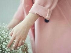 a close up of a person's hand holding a bouquet of flowers in front of her