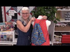 an older woman is holding up a piece of fabric