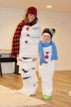 a woman standing next to a child in a snowman costume