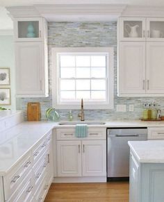 a kitchen with white cabinets and wood floors