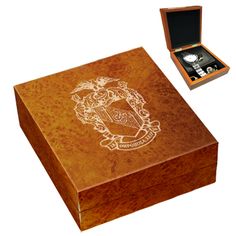 a wooden box with a watch in it and an emblem on the lid that is engraved