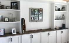 a living room filled with lots of white cabinets and shelves covered in pictures on top of them