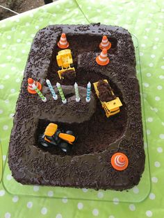 there is a chocolate cake with construction trucks on it