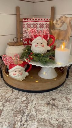 some christmas decorations are sitting on a tray with candles and other items in the background