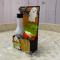 a halloween treat box on a table with ghost tags, candy and other treats in it