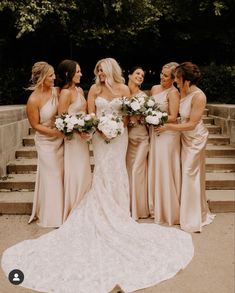 a group of women standing next to each other in front of some stairs with flowers