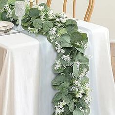 the table is decorated with white flowers and greenery