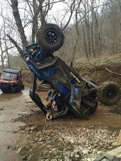 an off - road vehicle is stuck in the mud with it's front wheels up