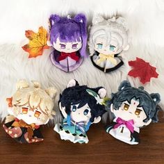 four little anime dolls sitting on top of a wooden table