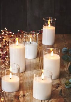 white candles are arranged on a wooden table