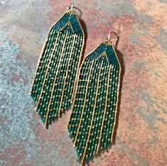 green beaded earrings with fringes on them