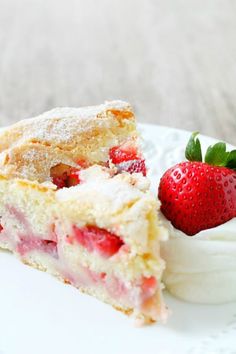 a piece of cake and a strawberry on a plate