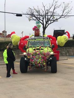 the vehicle is decorated with decorations and people are standing around in the parking lot next to it