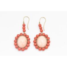 This is part of Chairish’s Fine Jewelry assortment.  These earrings feature a large oval cabochon angel skin coral piece measuring approximately  .80" x .60" set in a frame of orange coral beads measuring approximately 5.5 mm each.  The earrings dangle off an 18k yellow gold wire.  Pierced ears are required to wear these. Formal Coral Jewelry With Cabochon Details, Formal Coral Jewelry With Cabochon, Vintage Oval Coral Jewelry, Vintage Coral Oval Jewelry, Coral Oval Cabochon Jewelry, Oval Coral Cabochon Jewelry, Elegant Oval Coral Jewelry, Elegant Coral Oval Jewelry, Formal Coral Oval Jewelry