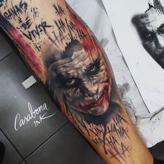 a man's arm covered in graffiti with a joker face on it and the words,