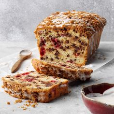 a loaf of fruit cake next to a bowl of yogurt