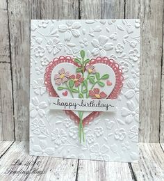 a heart shaped card with flowers on it