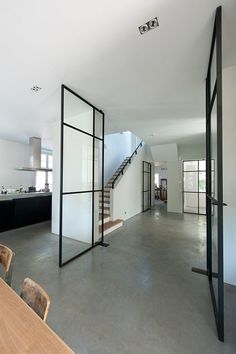 an open floor plan with white walls and black glass partitions in the center area