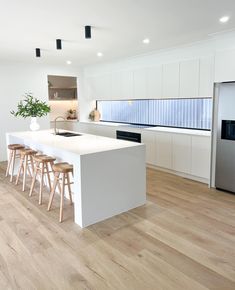 a kitchen with an island and stools in it