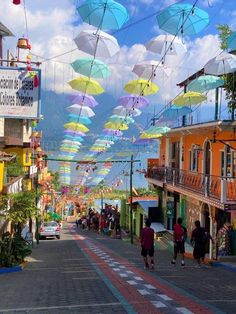 people walking down the street under umbrellas