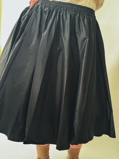 A classic flared skirt reimagined, the Bira Silk Taffeta Skirt has opulent organic gathers, creating movement and soft drama. Elastic waist for comfort, flared silhouette, cut in luminous silk taffeta. Wear with our Neruda Blouse, or your favourite black tee, or with our Frou Crinoline Skirt for added volume. Made in New York's Garment District by a small team of dedicated seamstresses. Ships in 10 business days. Evening A-line Skirt With Pleated Waist, Silk A-line Flowy Skirt, Silk Midi Dress With Gathered Skirt, Cocktail A-line Skirt With Pleated Waist, Silk A-line Evening Skirt, Fitted Flared Skirt With Gathered Waist, Flowy Skirt With Folds, Full Evening Skirt With Folds, Evening Full Skirt With Folds