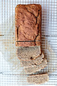 a loaf of bread sitting on top of a cooling rack next to two slices of bread