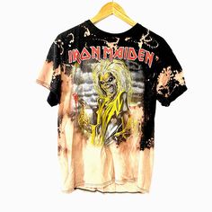 an iron maiden t - shirt hanging on a hanger