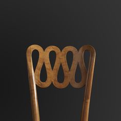 a wooden chair with four circles on it's back and seat, in front of a black background