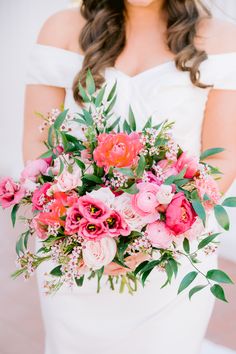 a woman holding a bouquet of flowers in her hands