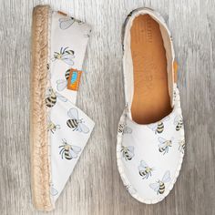 a pair of white shoes with bees on them