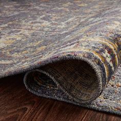 an area rug with wood flooring on top of it and a wooden floor in the background